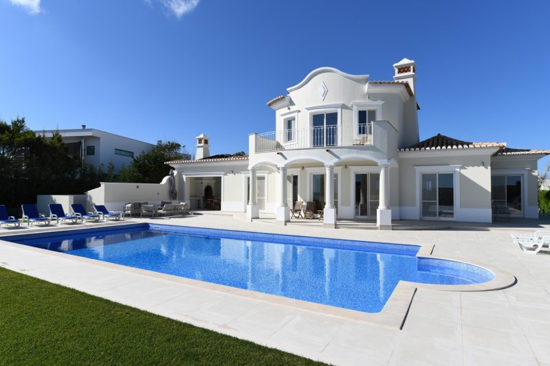 exterior of luxury holiday villa with blue sky and beautiful swi
