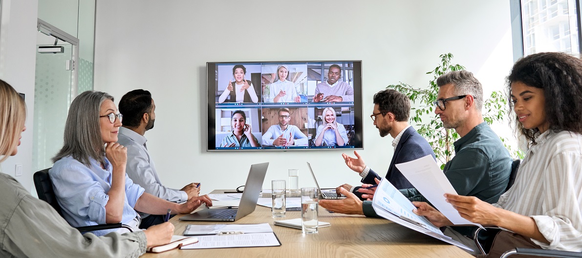 diverse employees on online conference video call on tv screen in meeting room.