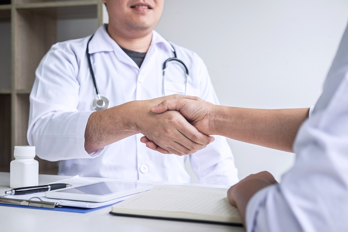 doctor having shaking hands to congrats with patient after recom
