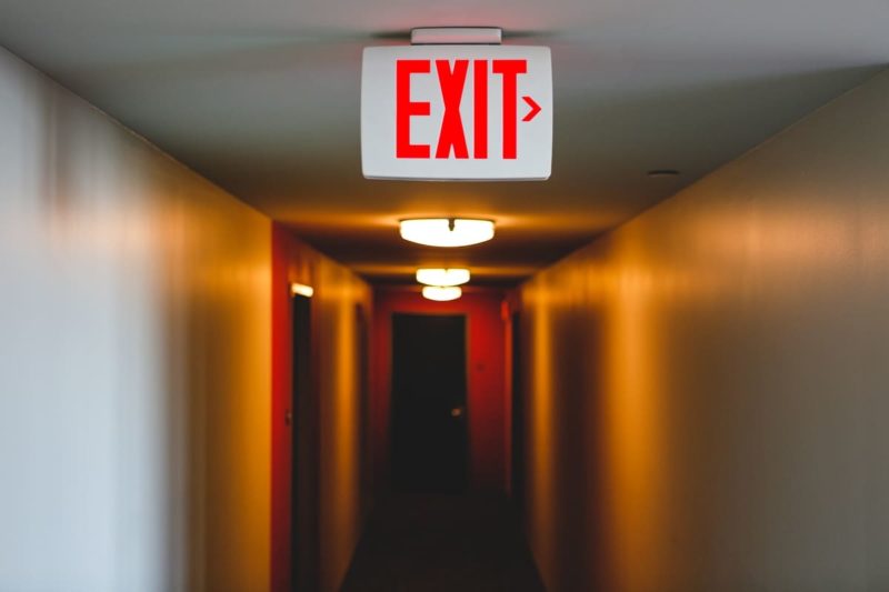 exit sign in a lit up long hallway exit to right 2022 11 15 18 00 34 utc(1)(1)